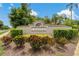 A community sign and lush shrubbery showcase a welcoming entrance to the neighborhood at 1046 Middlesex Dr, New Port Richey, FL 34655