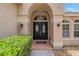 Elegant front entrance featuring double doors, decorative lighting, and mature landscaping for added curb appeal at 1046 Middlesex Dr, New Port Richey, FL 34655