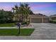 Charming single-story home featuring a well-manicured lawn, mature palm trees, and a three-car garage at 1046 Middlesex Dr, New Port Richey, FL 34655
