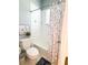 Cozy bathroom showcasing a toilet, shower/tub combo with decorative curtain, and neutral tiling at 11501 Norval Pl, Temple Terrace, FL 33617