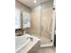 Modern bathroom boasts tile shower and soaking tub combo, great natural light, and stylish fixtures at 11501 Norval Pl, Temple Terrace, FL 33617