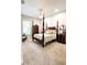 Bedroom featuring a four-poster bed, neutral carpet, and traditional decor at 11501 Norval Pl, Temple Terrace, FL 33617