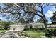Charming single-story home featuring a well-manicured lawn, mature landscaping, and a spacious three-car garage at 11501 Norval Pl, Temple Terrace, FL 33617
