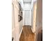 Hallway with hardwood floors, white walls, and an array of framed pictures at 11501 Norval Pl, Temple Terrace, FL 33617