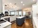 This open concept kitchen features white cabinets, an island, and a stainless steel refrigerator at 11501 Norval Pl, Temple Terrace, FL 33617
