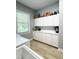 Well-lit laundry room with white cabinets, tile floors and a window at 11501 Norval Pl, Temple Terrace, FL 33617