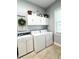 Well-equipped laundry room with white cabinets, a sink, and a washer and dryer at 11501 Norval Pl, Temple Terrace, FL 33617