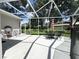 Spacious screened-in patio with ample seating and views of the green backyard at 11501 Norval Pl, Temple Terrace, FL 33617