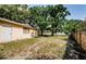 Spacious backyard with a mix of grass and bare spots, featuring a classic white back door at 11783 102Nd Ave, Largo, FL 33778