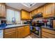 Well-lit kitchen with wood cabinets, stainless steel appliances, and tile backsplash at 11783 102Nd Ave, Largo, FL 33778