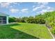 A large backyard features a lush lawn and mature trees and landscaping at 13116 Marathon Blvd, Port Charlotte, FL 33981