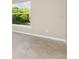 Bright, neutral toned bedroom with an exterior window offering natural light, complemented by tile flooring at 13116 Marathon Blvd, Port Charlotte, FL 33981