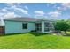 An exterior view shows a well-manicured lawn and a screened-in patio in the rear of the home at 13116 Marathon Blvd, Port Charlotte, FL 33981
