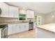 Close up on bright kitchen featuring granite counters, stainless appliances, white cabinetry, and backyard access at 13116 Marathon Blvd, Port Charlotte, FL 33981