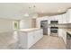 Open concept kitchen features stainless steel appliances, a granite center island, and a view to the living area at 13116 Marathon Blvd, Port Charlotte, FL 33981