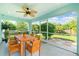 Covered and screened lanai area with a wood table and chairs for outdoor dining and relaxation at 13116 Marathon Blvd, Port Charlotte, FL 33981