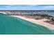Expansive aerial view of a long sandy beach and blue ocean waters with cityscape in the distance at 1340 Gulf Blvd # 12A, Clearwater Beach, FL 33767