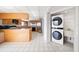 Open kitchen featuring light wood cabinetry and white tile floors, next to a laundry closet at 1340 Gulf Blvd # 12A, Clearwater Beach, FL 33767
