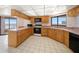 Traditional kitchen with light wood cabinets, white tile floors, and stunning views of the water at 1340 Gulf Blvd # 12A, Clearwater Beach, FL 33767