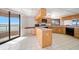Spacious kitchen with light wood cabinetry, tile floors, and adjacent balcony access at 1340 Gulf Blvd # 12A, Clearwater Beach, FL 33767
