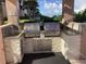 Outdoor kitchen with stainless steel grills, sink, granite countertop and stone accents at 1340 Gulf Blvd # 12A, Clearwater Beach, FL 33767