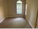 Bright bedroom with neutral carpet, tan walls, and an arched window providing natural light at 1353 El Pardo Dr, Trinity, FL 34655