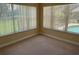 Carpeted bedroom with large windows showing the green backyard and filled with natural light at 1353 El Pardo Dr, Trinity, FL 34655