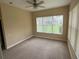 Spacious carpeted bedroom with a ceiling fan and large windows with vertical blinds at 1353 El Pardo Dr, Trinity, FL 34655