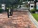 Gated entrance to the community featuring brick-paved entrance and decorative ironwork at 1353 El Pardo Dr, Trinity, FL 34655