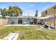 Home's backyard features a patio, grill, lounge chairs, awning, and privacy fence at 1406 Nebraska Ave, Palm Harbor, FL 34683