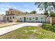 Well-maintained home featuring a long driveway, manicured lawn, and flowering plants enhancing its curb appeal at 1406 Nebraska Ave, Palm Harbor, FL 34683