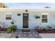 Charming front door with modern tile walkway, decorative plants and hanging flower baskets, providing great curb appeal at 1406 Nebraska Ave, Palm Harbor, FL 34683