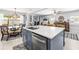 Kitchen island featuring a stainless-steel dishwasher, sink, and barstool seating overlooking the living area at 1406 Nebraska Ave, Palm Harbor, FL 34683