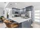 Well-appointed kitchen boasts gray cabinetry, stainless steel appliances, and a spacious island with barstool seating at 1406 Nebraska Ave, Palm Harbor, FL 34683