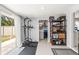 Bright laundry room features storage shelves, washer, dryer, and a sliding glass door at 1406 Nebraska Ave, Palm Harbor, FL 34683