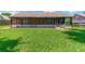 Green backyard featuring a screened lanai, ideal for outdoor relaxation and entertaining at 1604 Dusty Rose Ln, Brandon, FL 33510