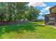 Expansive backyard with lush green grass, mature trees, and a privacy fence at 1604 Dusty Rose Ln, Brandon, FL 33510