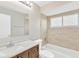 A full bathroom featuring a vanity, toilet, and tiled tub/shower with a window at 1604 Dusty Rose Ln, Brandon, FL 33510