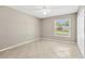 A neutrally painted bedroom with a ceiling fan, bright windows, and tile flooring at 1604 Dusty Rose Ln, Brandon, FL 33510