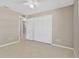 A neutrally painted bedroom with multiple white closets and a light-colored tile floor at 1604 Dusty Rose Ln, Brandon, FL 33510