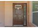 A brown paneled front door with a glass window on the right side, and a keypad at 1604 Dusty Rose Ln, Brandon, FL 33510