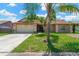 Charming single story home featuring a two-car garage and an American flag displayed in the front yard at 1604 Dusty Rose Ln, Brandon, FL 33510
