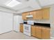 Well-lit kitchen with wooden cabinets, modern white appliances, and tile flooring at 1604 Dusty Rose Ln, Brandon, FL 33510