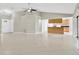 Open living room features a ceiling fan, neutral paint, an adjacent kitchen and access to the front door at 1604 Dusty Rose Ln, Brandon, FL 33510