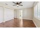 Bedroom with laminate floors, ceiling fan, double closet doors, and an ensuite bathroom at 1717 Danbury Dr, Sun City Center, FL 33573