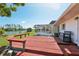 Exterior view showcasing a wooden deck, screened lanai, and tranquil lakefront, ideal for relaxation at 1717 Danbury Dr, Sun City Center, FL 33573