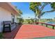 Wooden deck with bench seating provides stunning waterfront views, surrounded by lush greenery at 1717 Danbury Dr, Sun City Center, FL 33573