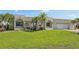 Charming single-story home with a lush green lawn and mature palm trees enhancing curb appeal at 1717 Danbury Dr, Sun City Center, FL 33573