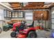 Organized garage space featuring a Craftsman riding mower and storage solutions, tool and work benches at 1717 Danbury Dr, Sun City Center, FL 33573