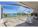 Screened lanai with stone tile flooring and scenic lake views, perfect for relaxing or entertaining at 1717 Danbury Dr, Sun City Center, FL 33573